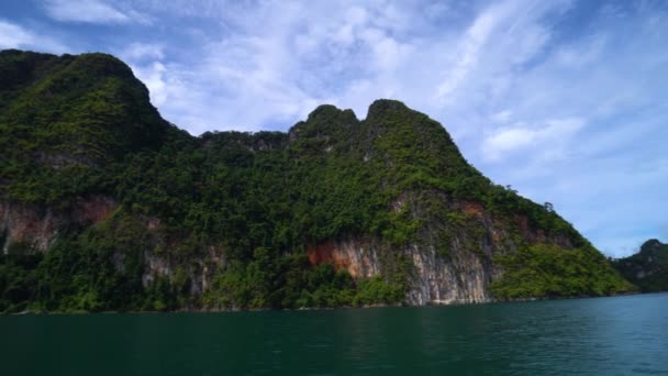 Longtail-båt seglar längs Cheow lan sjön bland vackra berg och klippor. — Stockvideo