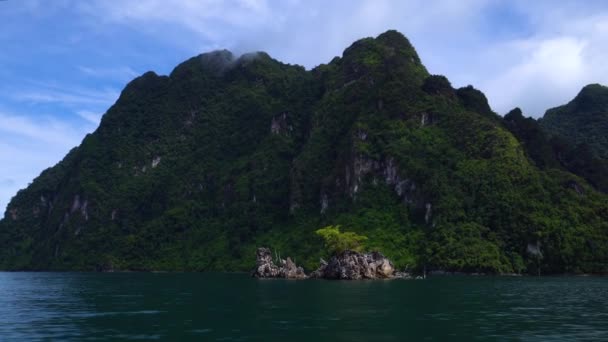 Un piccolo isolotto sul lago e alte montagne con giungle sullo sfondo . — Video Stock