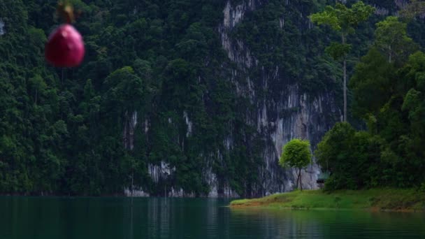 Filmischer Blick auf die kleine Insel am See mit einem kleinen Holzhaus. — Stockvideo