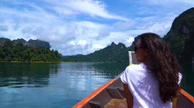 Kızı yağmur ormanları arasında güzel bir göle bir teknede yelken.