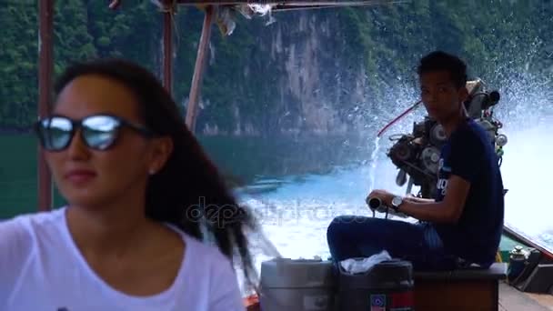 Thai guy carries a girl looking forward on a longtail boat. — Stock Video