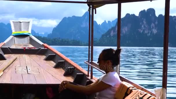 Asyalı kız göle dağların arasında bir longtail teknede yelken. — Stok video