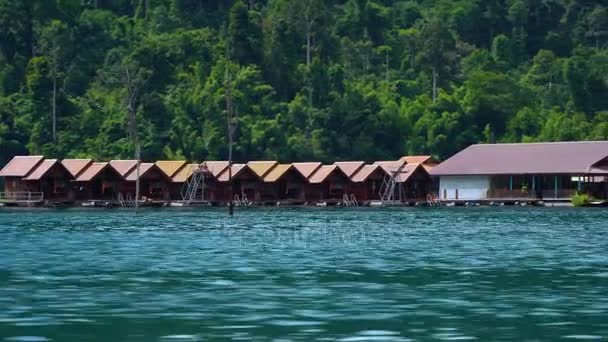 Une base touristique avec de petites maisons sur le lac parmi les montagnes . — Video