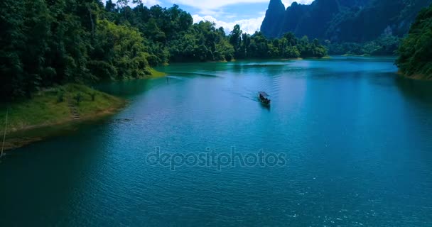 Aérien : Le bateau navigue le long du lac entre les montagnes et la jungle . — Video