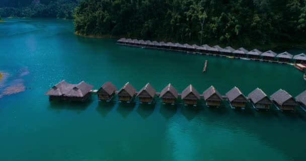 Aerial: The hostel on the lake with thatched roofs houses on the water. — Stock Video