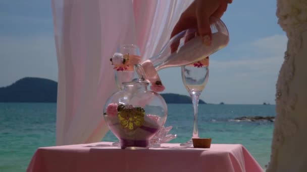 La mariée verse du sable dans le vase. Décoration de mariage près de la mer . — Video