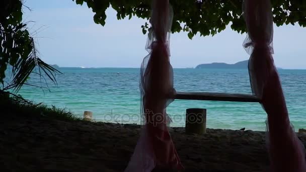 在树下举行婚礼的绳索秋千和海滩上的拱门. — 图库视频影像