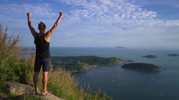 体育青年男子站在山的边缘, 他的手. — 图库视频影像