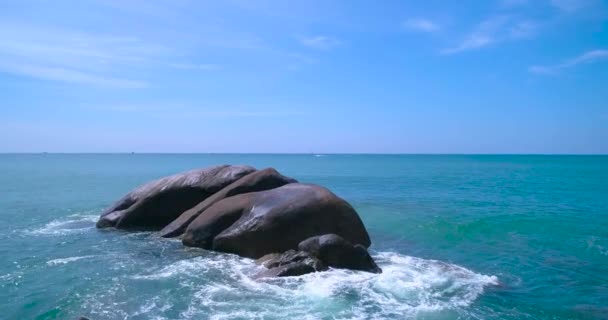 Luchtfoto: De golven zijn aangespoeld en botste op een grote rots in de zee. — Stockvideo