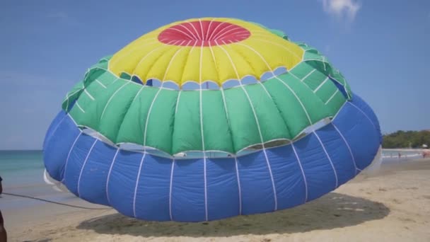 Phuket, thailand dezember 2017: ein mann richtet den fallschirm am strand — Stockvideo