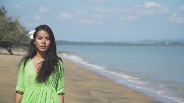 Όμορφο κορίτσι της Ασίας περπάτημα κατά μήκος της παραλίας σε ένα πράσινο φόρεμα. — Αρχείο Βίντεο