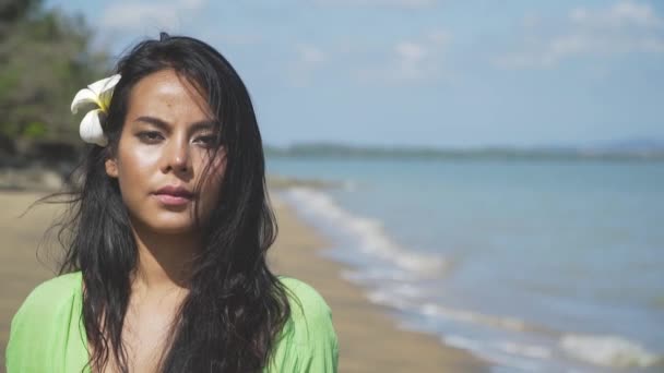 Close-up de uma bela menina asiática andando ao longo da praia em um vestido verde . — Vídeo de Stock