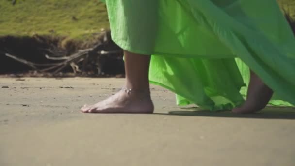 Lábát a lány séta a homokot egy zöld ruha.