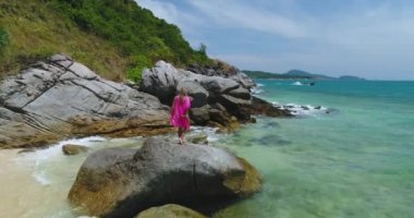 Hava: Genç güzel kız sahilde büyük bir taş üstüne poz.