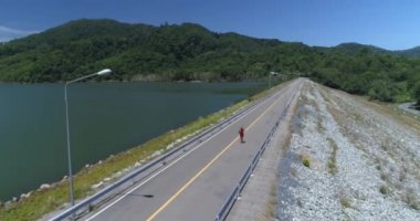 Hava: Bir yalnız kadın yolda baraj üzerinde yürüyor.