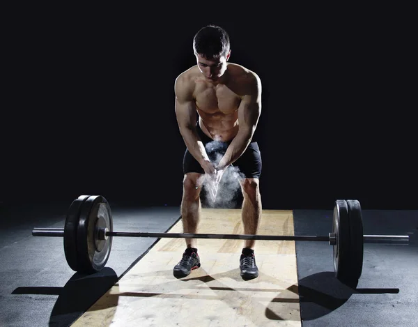 closeup of weightlifter clapping hands before barbell workout at