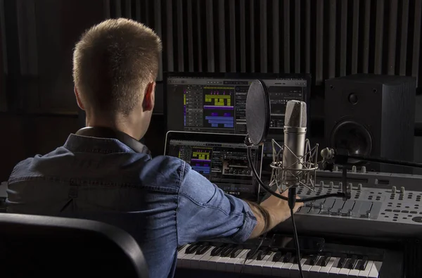 Musician working and producing music in his modern sound studio