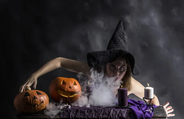 Attractive witch in the wizarding lair with smoke going from her