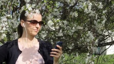 Güzel kız Çiçek bahçesinde müzik dinlemek