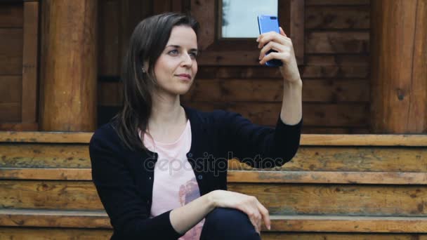 Привлекательная молодая девушка позирует, чтобы сделать селфи на мобильном — стоковое видео