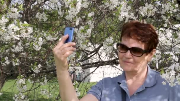 Mujer mayor tomando fotos en el móvil al aire libre — Vídeos de Stock