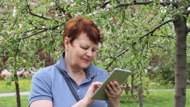 Femme âgée navigation pavé tactile à l'extérieur — Video