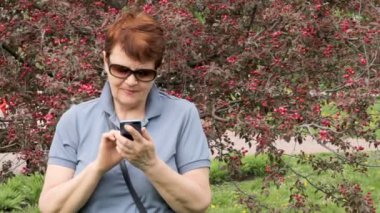 Yaşlı kadın cep telefonu metin yazma