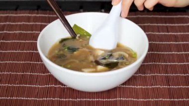 Miso çorbası seçmek dışarı tofu pirzola ile kaşıkla karıştırarak eller