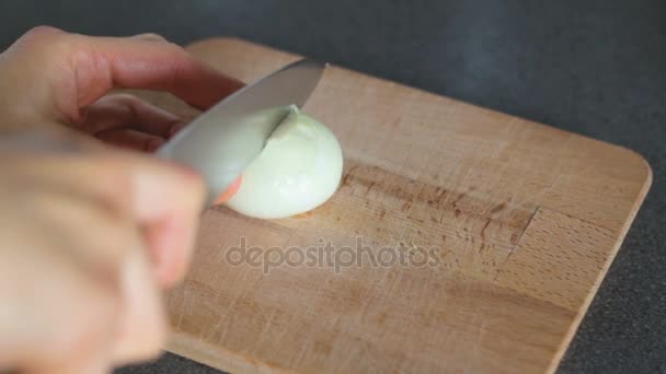 Oignon blanc coupé au couteau sur une planche de bois — Video