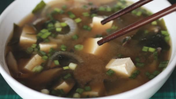 Picking up diced tofu from miso soup — Stock Video