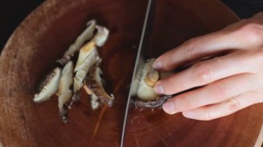 Shiitake mantar ahşap tahta üzerinde bıçak ile kesmek