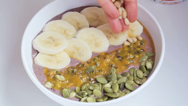 Topping tazón de batido con nueces de cedro — Vídeos de Stock