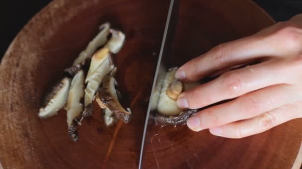 Setas Shiitake cortadas con cuchillo sobre tabla de madera — Vídeos de Stock