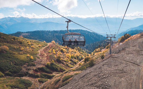 People in chair lift in mountains