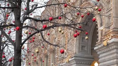 Tarihi bina, sakız (devlet mağaza) Moskova'da ışıklı önünde dışarıda ağaçlar dekorasyon kırmızı ve altın baubles. Yukarı eğimli
