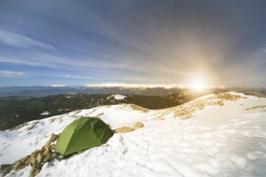 Dağlarda bir sırt çantası ve çadır kamp kış.