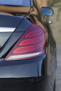 Arka ışık yansıması ile modern bir siyah araba.