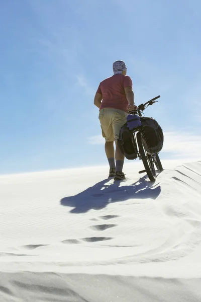 Člověk na cestách na kole v poušti. — Stock fotografie
