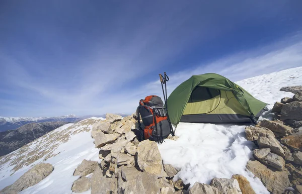 Winter camping in the mountains with a backpack and tent.