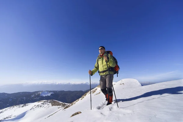 Bir sırt çantası ile dağlarda hiking kış. — Stok fotoğraf