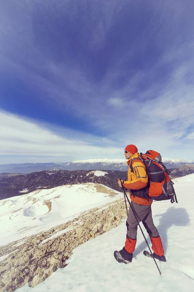 Winterwandelen in de bergen met een rugzak. — Stockfoto