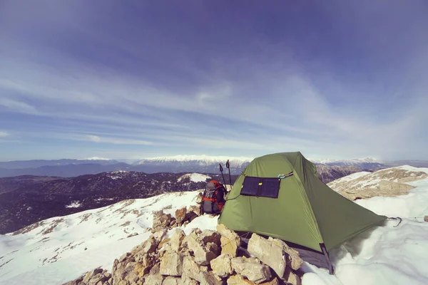 Wintercamping in de bergen met een rugzak en tent. — Stockfoto