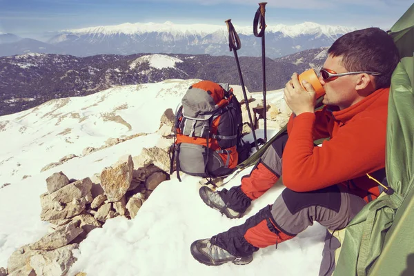 Winter camping in the mountains with a backpack and tent.