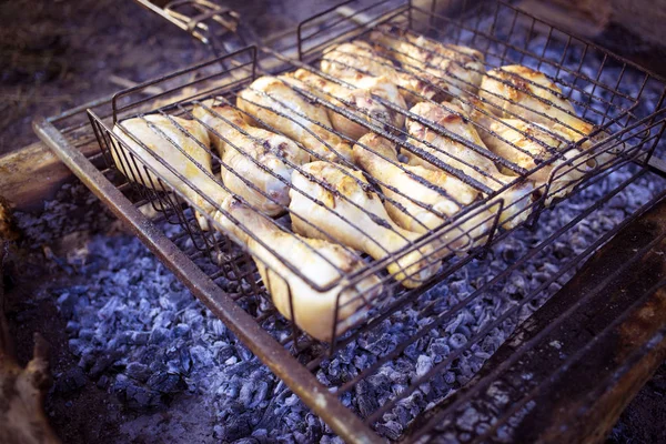 Cook chicken over an open fire at the camp. — Stock Photo, Image