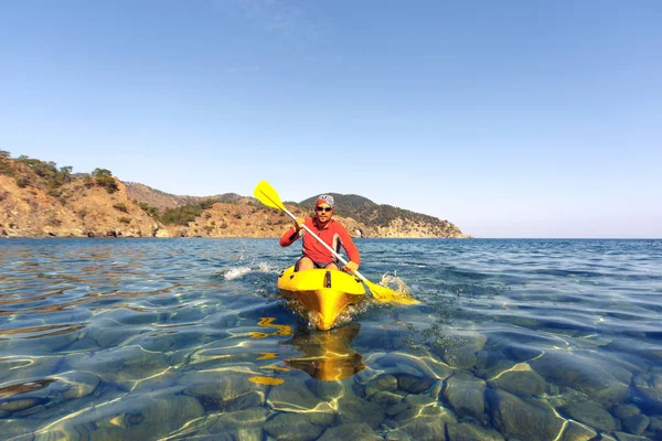 Un homme voyageant en canot le long de la côte . — Photo