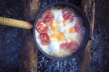 Bir kamp kamp ateşi üzerinde yemek kahvaltı.