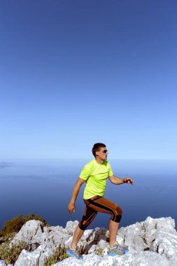 Dağlarda zor arazi üzerinde çalışan adam.