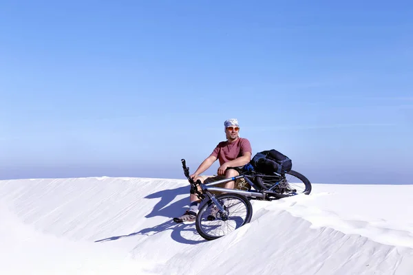 骑着自行车在沙漠中旅行的人. — 图库照片