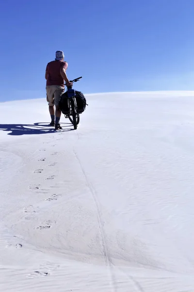 骑着自行车在沙漠中旅行的人. — 图库照片