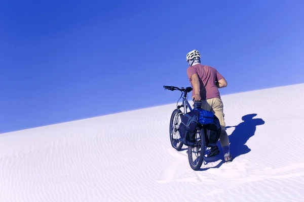 Traveling man on a bicycle in the desert. — Stock Photo, Image